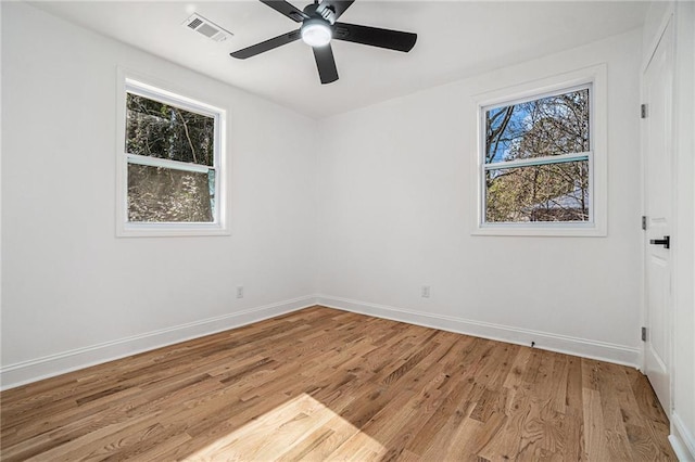 empty room with ceiling fan, light hardwood / wood-style floors, and a wealth of natural light