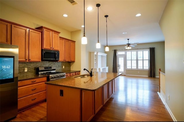 1668 Sabastian Pt NE, Atlanta, GA 30329 - kitchen featuring appliances with stainless steel finishes, brown cabinetry, dark wood-type flooring, a center island with sink, and recessed lighting