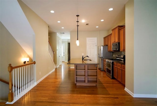 1668 Sabastian Pt NE, Atlanta, GA 30329 - kitchen with stainless steel appliances, dark countertops, brown cabinetry, recessed lighting, and wood finished floors