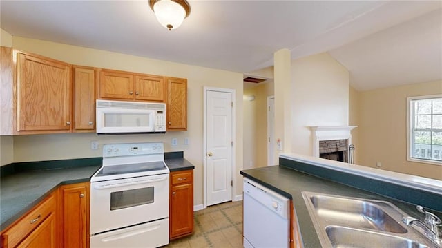 kitchen featuring sink, white appliances, and a fireplace