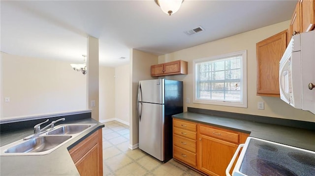 kitchen featuring sink, stainless steel fridge, and stove