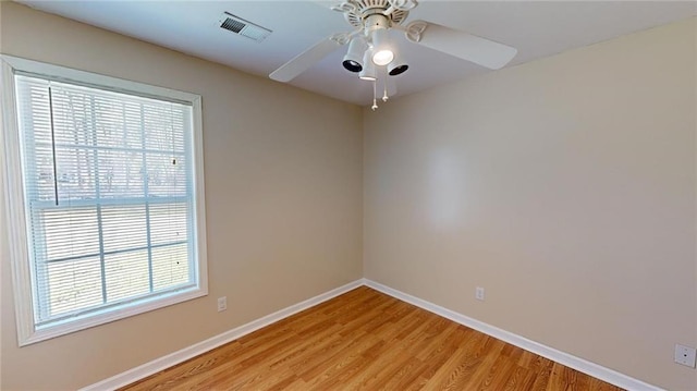 spare room featuring ceiling fan, a wealth of natural light, and light hardwood / wood-style flooring