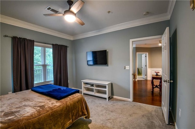 carpeted bedroom featuring ceiling fan and crown molding