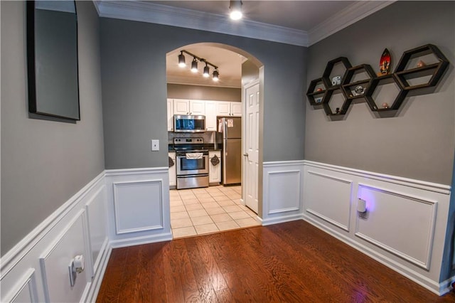 interior space with track lighting, crown molding, and light hardwood / wood-style floors