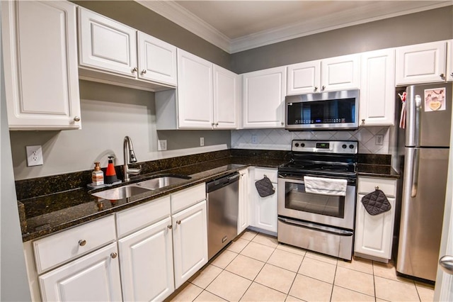 kitchen with light tile patterned flooring, white cabinets, stainless steel appliances, crown molding, and sink