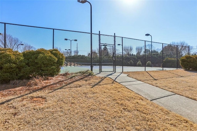 view of sport court with a lawn