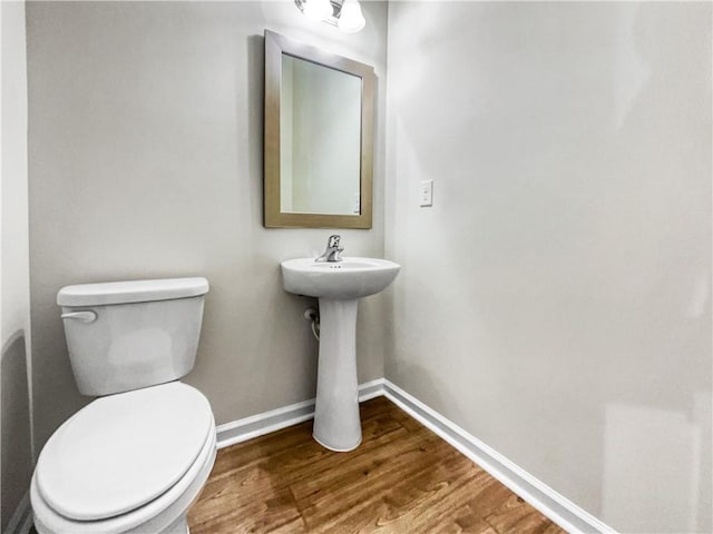 bathroom with toilet and wood-type flooring