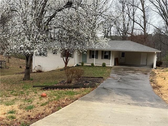 ranch-style house with brick siding, a carport, and driveway