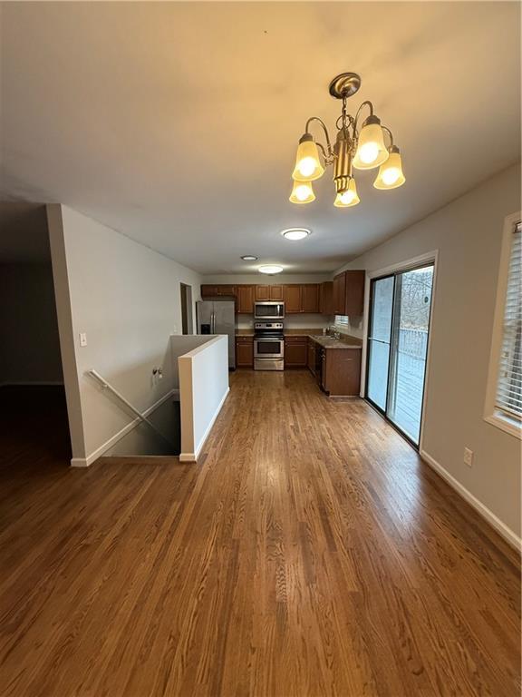 184 Wana Cir SE, Mableton, GA 30126 - kitchen featuring baseboards, a chandelier, stainless steel appliances, and dark wood finished floors