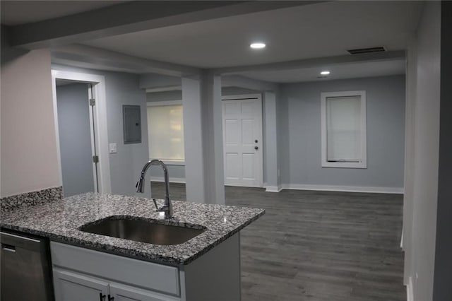 kitchen featuring sink, electric panel, dark hardwood / wood-style flooring, stainless steel dishwasher, and dark stone counters