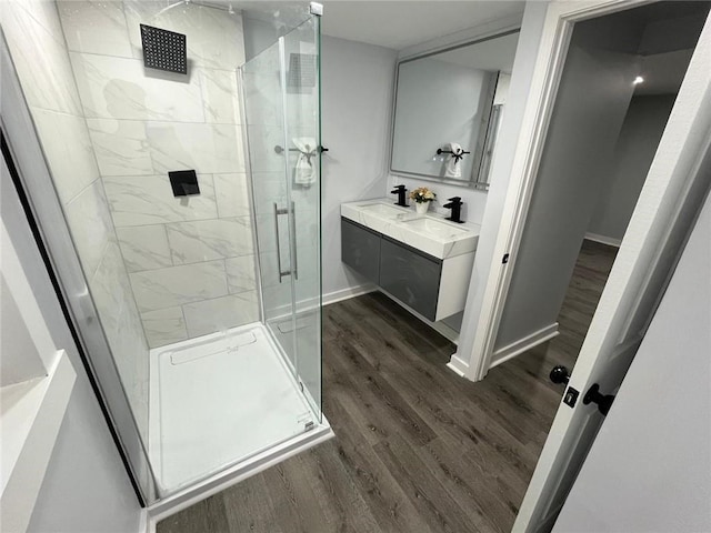 bathroom featuring hardwood / wood-style flooring, vanity, and an enclosed shower