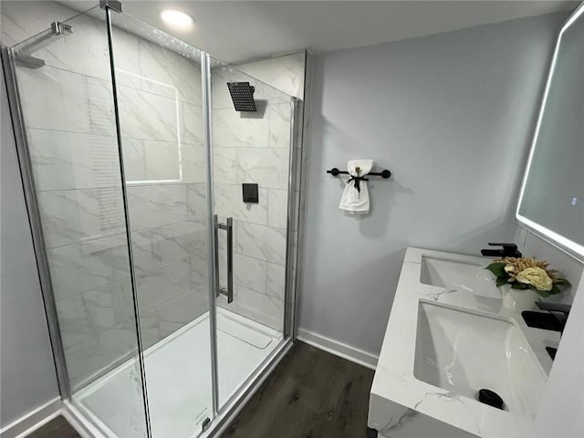 bathroom with hardwood / wood-style flooring, vanity, and walk in shower