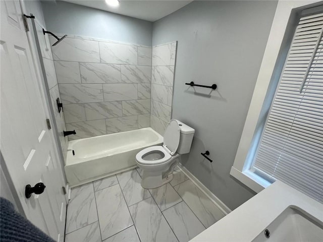 bathroom featuring tiled shower / bath and toilet