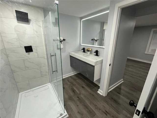 bathroom with a shower with door, vanity, and hardwood / wood-style floors