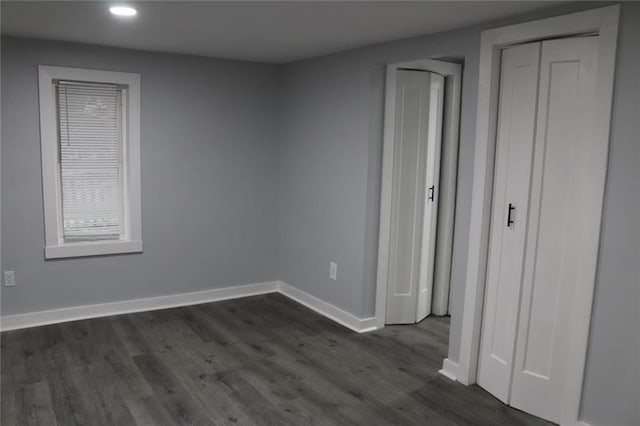 unfurnished bedroom with dark hardwood / wood-style flooring