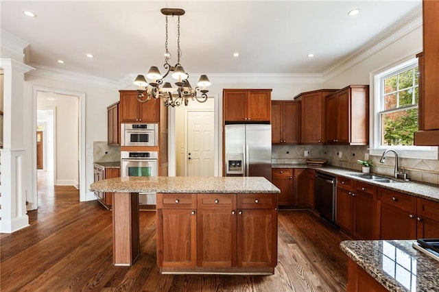 kitchen featuring pendant lighting, a center island, sink, appliances with stainless steel finishes, and a chandelier