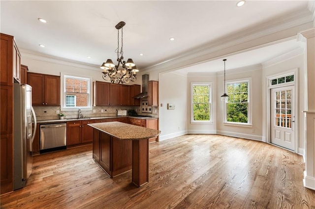 kitchen featuring a center island, stainless steel appliances, decorative light fixtures, and sink