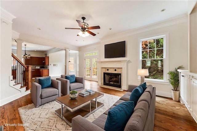 living room with plenty of natural light, light wood-type flooring, and ornamental molding