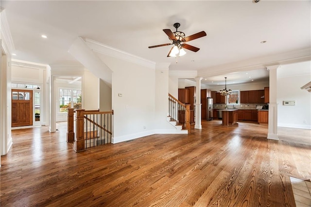 unfurnished living room featuring hardwood / wood-style floors, ceiling fan with notable chandelier, and ornamental molding