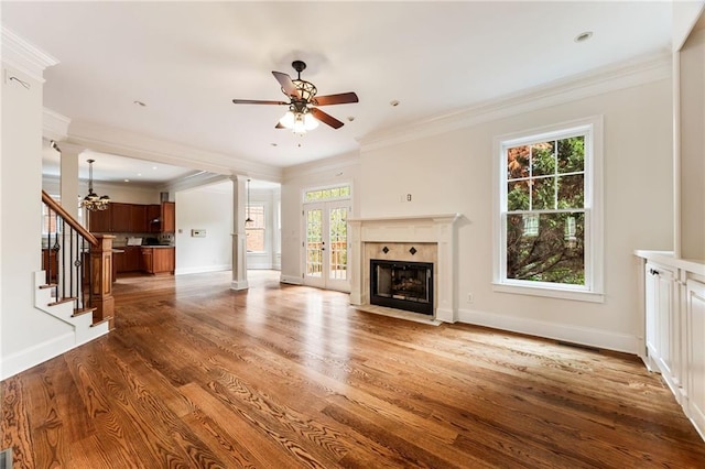 unfurnished living room with dark hardwood / wood-style flooring, ceiling fan, plenty of natural light, and ornamental molding