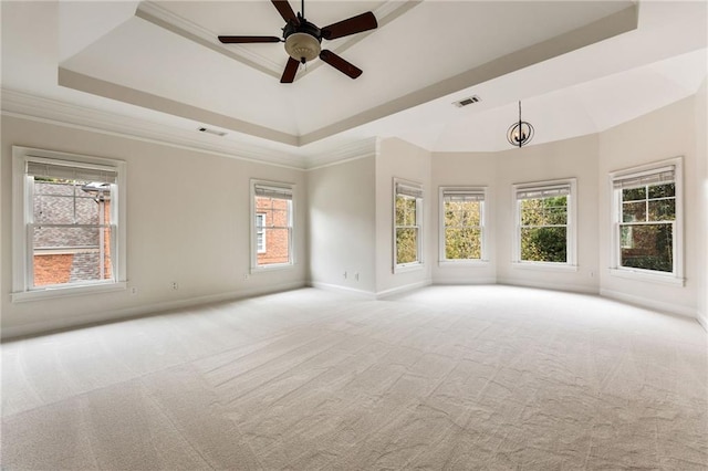 carpeted spare room featuring ceiling fan with notable chandelier, crown molding, and a tray ceiling