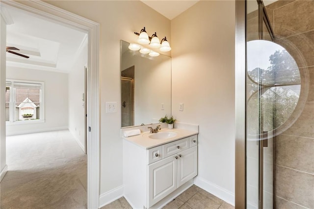 bathroom with vanity, a shower with door, tile patterned floors, a raised ceiling, and ceiling fan