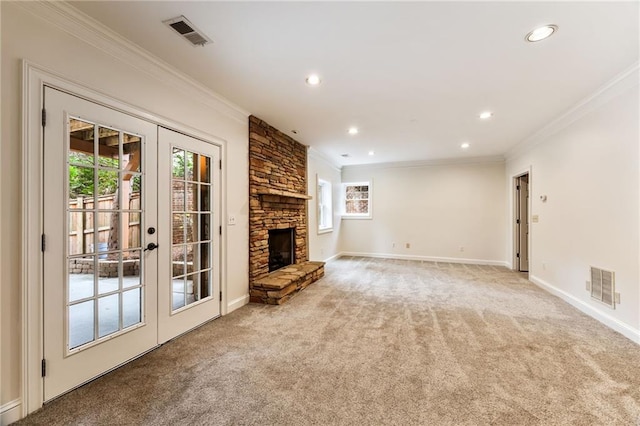 unfurnished living room featuring a stone fireplace, light carpet, plenty of natural light, and ornamental molding