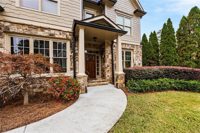 view of exterior entry with a lawn