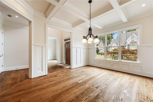 unfurnished dining area with beamed ceiling, a chandelier, coffered ceiling, and hardwood / wood-style flooring