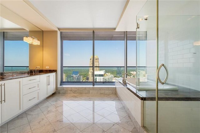 bathroom with vanity and independent shower and bath