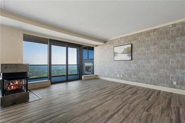 unfurnished living room with a multi sided fireplace and hardwood / wood-style floors