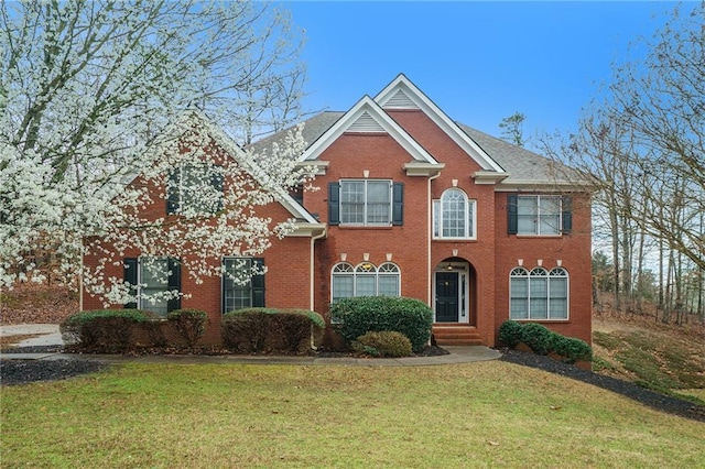 view of front facade featuring brick siding and a front lawn