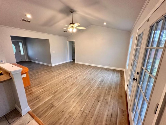 unfurnished living room with wood finished floors, baseboards, visible vents, ornamental molding, and vaulted ceiling