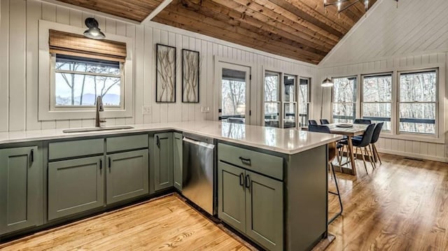 kitchen with a sink, stainless steel dishwasher, and green cabinetry