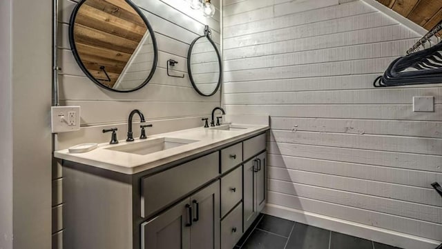 bathroom with double vanity, wood walls, and a sink