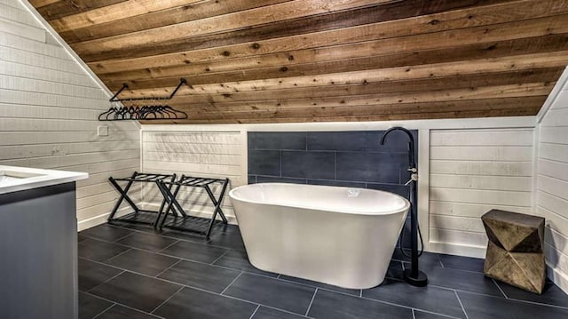 full bathroom with wood ceiling, lofted ceiling, tile patterned floors, a soaking tub, and vanity