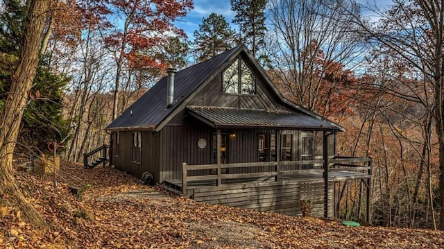 rustic home featuring metal roof and a deck