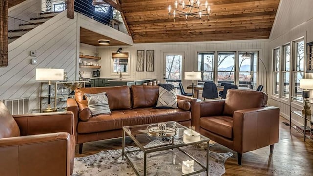 living room with visible vents, a healthy amount of sunlight, an inviting chandelier, and wood finished floors