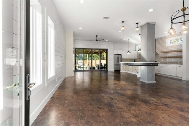 unfurnished living room with visible vents, finished concrete flooring, ceiling fan, recessed lighting, and a sink