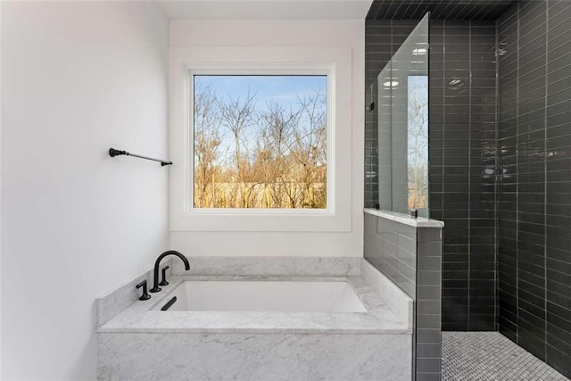 bathroom with a bath and a tile shower