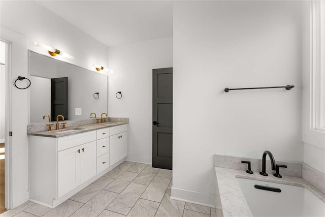 bathroom featuring double vanity, baseboards, a bathing tub, and a sink