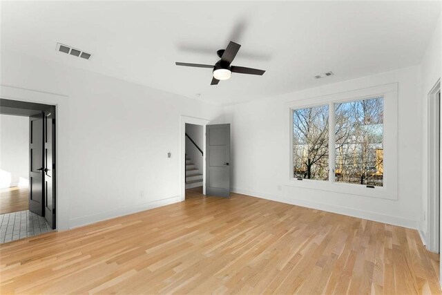 interior space with stairs, baseboards, visible vents, and light wood finished floors