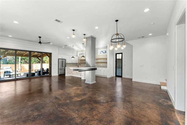 kitchen with recessed lighting, concrete flooring, freestanding refrigerator, and open floor plan
