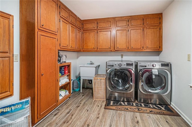 3003 Hanover Ln SE, Conyers, GA 30094 - laundry area with washing machine and clothes dryer, light wood-style flooring, and cabinet space