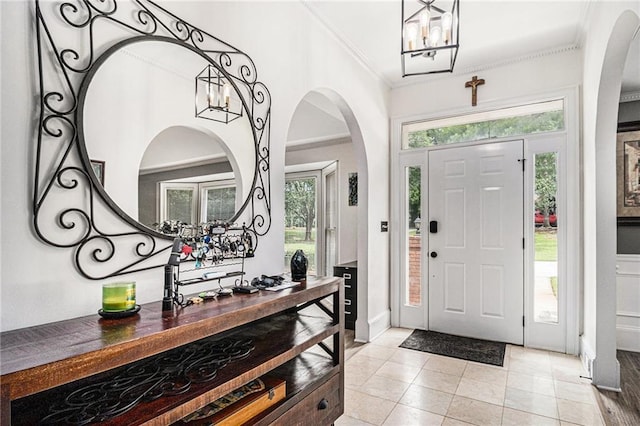 3003 Hanover Ln SE, Conyers, GA 30094 - foyer with a chandelier, ornamental molding, arched walkways, and light tile patterned flooring