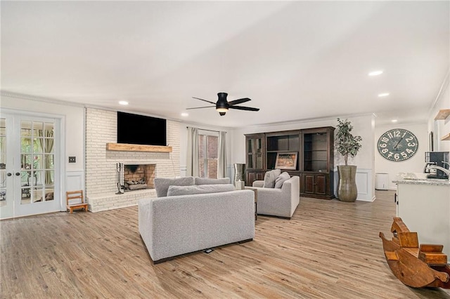 3003 Hanover Ln SE, Conyers, GA 30094 - living room with ornamental molding, light wood-style flooring, a ceiling fan, a brick fireplace, and recessed lighting