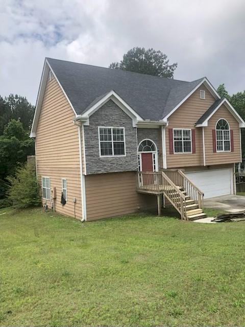 3275 Spincaster Way, Loganville, GA 30052 - split foyer home with an attached garage, a front yard, stone siding, and concrete driveway