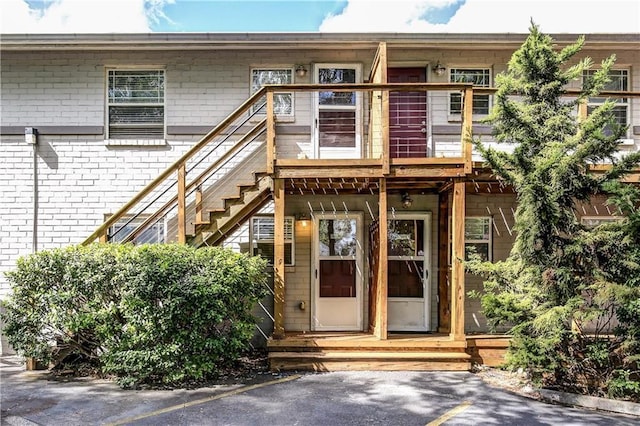 entrance to property with uncovered parking and brick siding