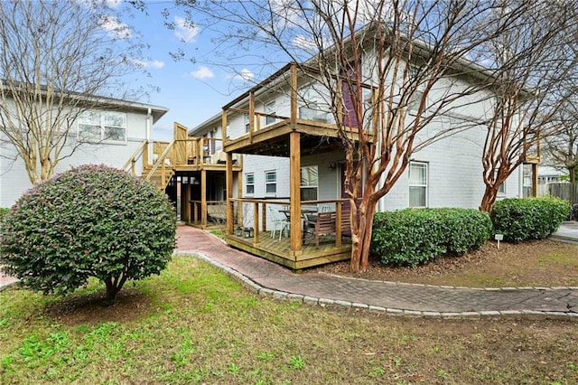 back of house with brick siding and a wooden deck