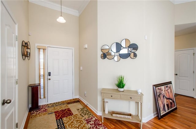 entryway with wood-type flooring and ornamental molding